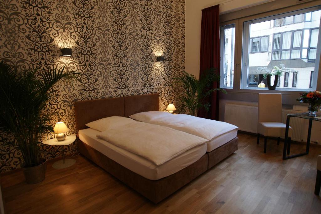 杜塞尔多夫斯特恩酒店的一间卧室配有一张床、一张桌子和一个窗户。