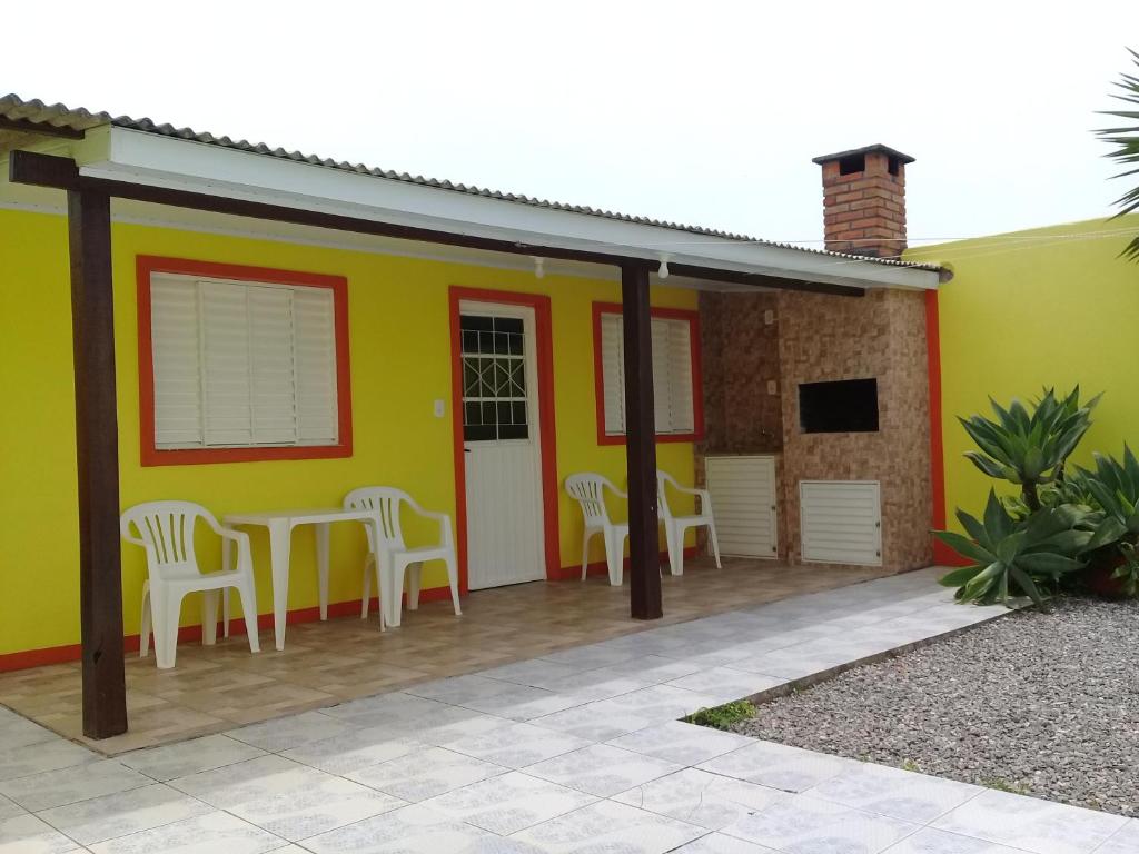 圣加布里埃尔Pousada Cabral的黄色的房子,配有桌子和椅子