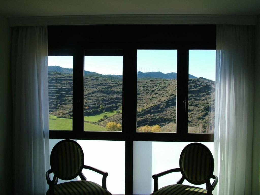 索斯-德尔雷卡托利科温纳库瓦酒店的两把椅子位于窗户前,享有美景