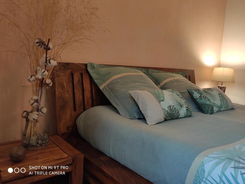 朗布依埃Les Prunelliers的一间卧室配有一张带蓝色床单和枕头的床。
