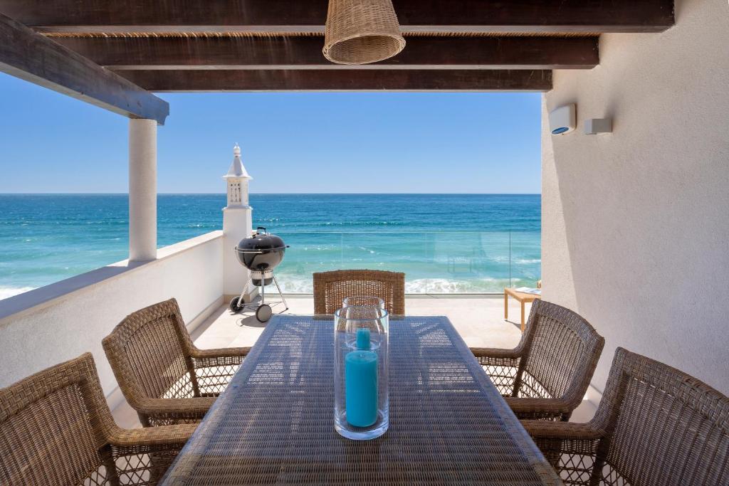 塞勒玛Residence Sol e Mar的海滩上一张桌子上放着蓝色瓶子
