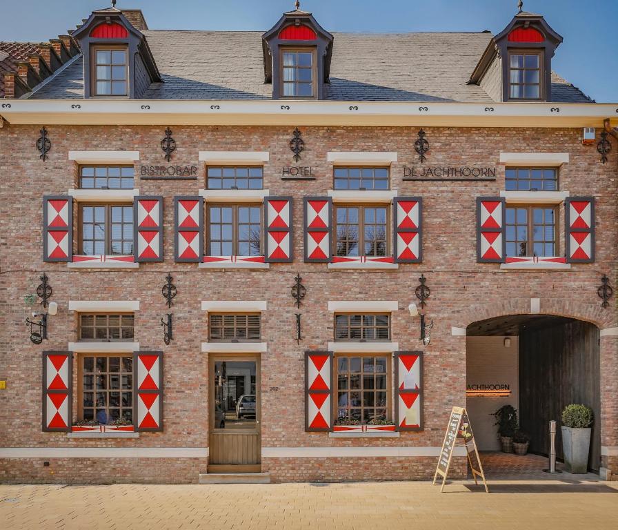 霍赫斯特拉滕Hotel De Jachthoorn的砖砌的建筑,上面有红白的方块