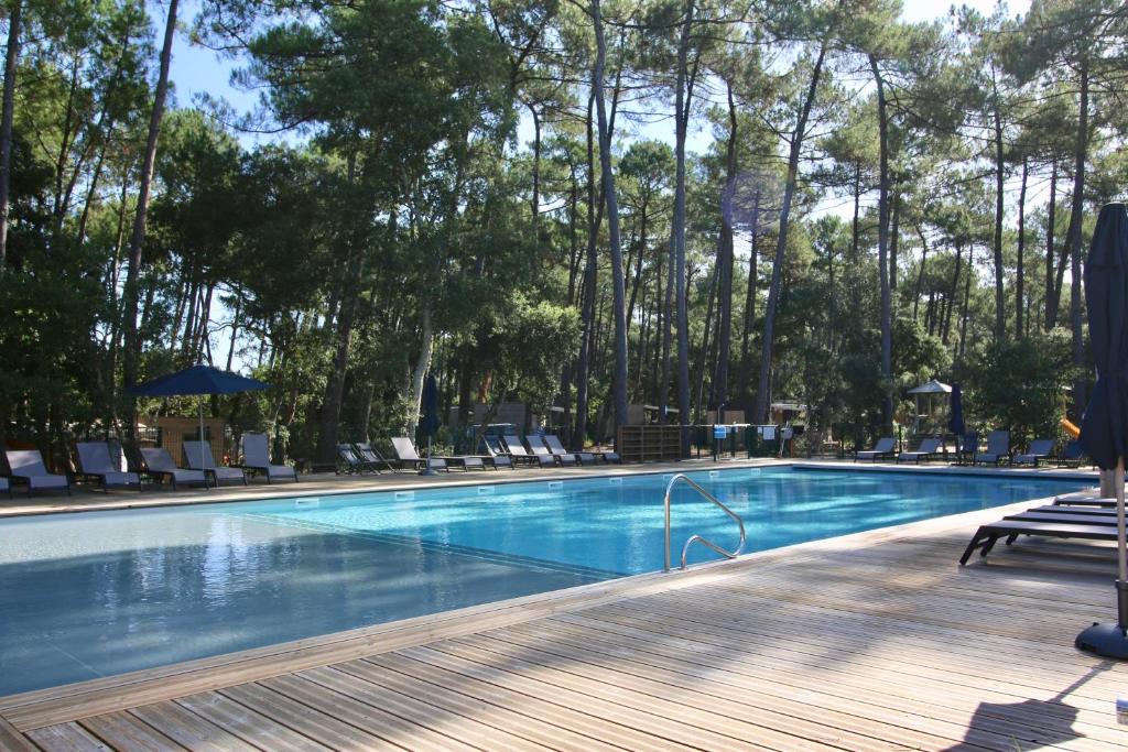 翁德尔Green Resort的一座带椅子和树木的游泳池