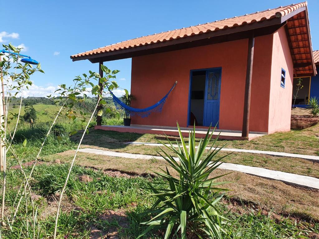 瓜拉雷马Sitio Aconchego Verde Guararema的一间红色的小房子,带蓝色门