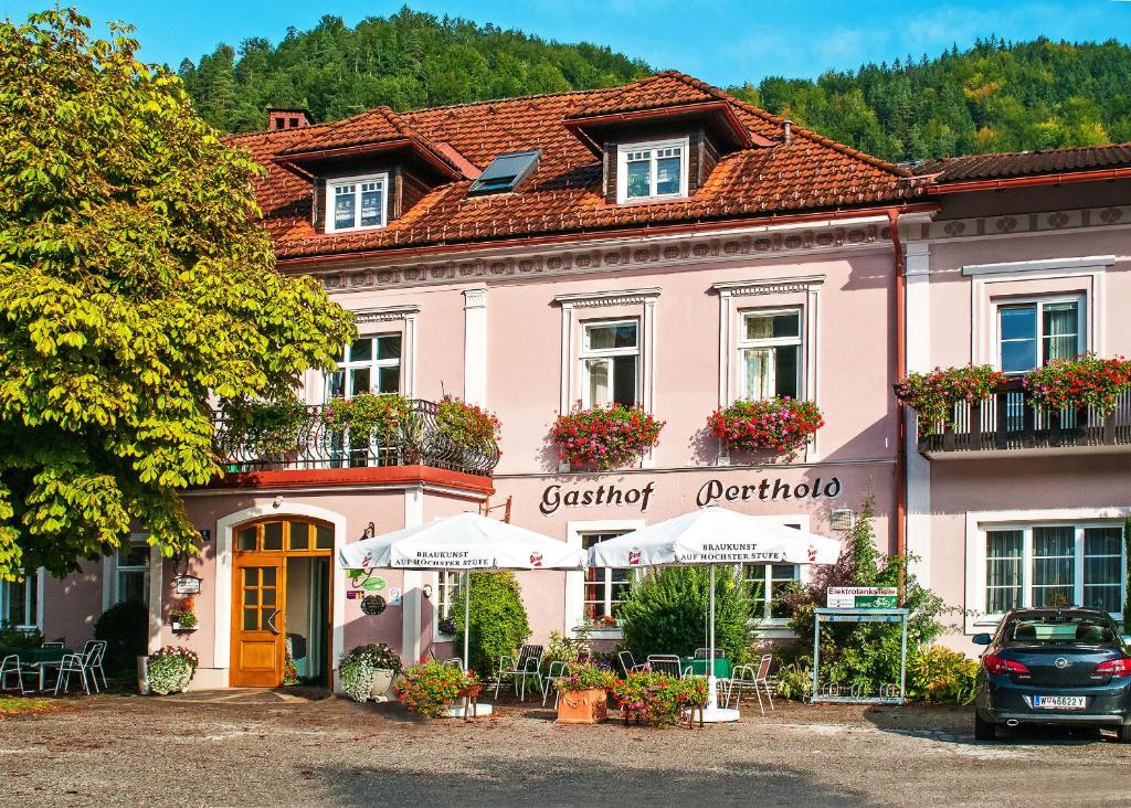 Sankt Aegyd am Neuwalde尼德豪斯 － 皮尔斯豪德酒店的粉红色的建筑,前面设有桌椅
