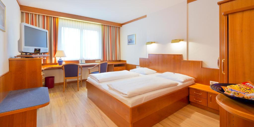 维也纳Vienna Sporthotel的配有一张床和一张书桌的酒店客房