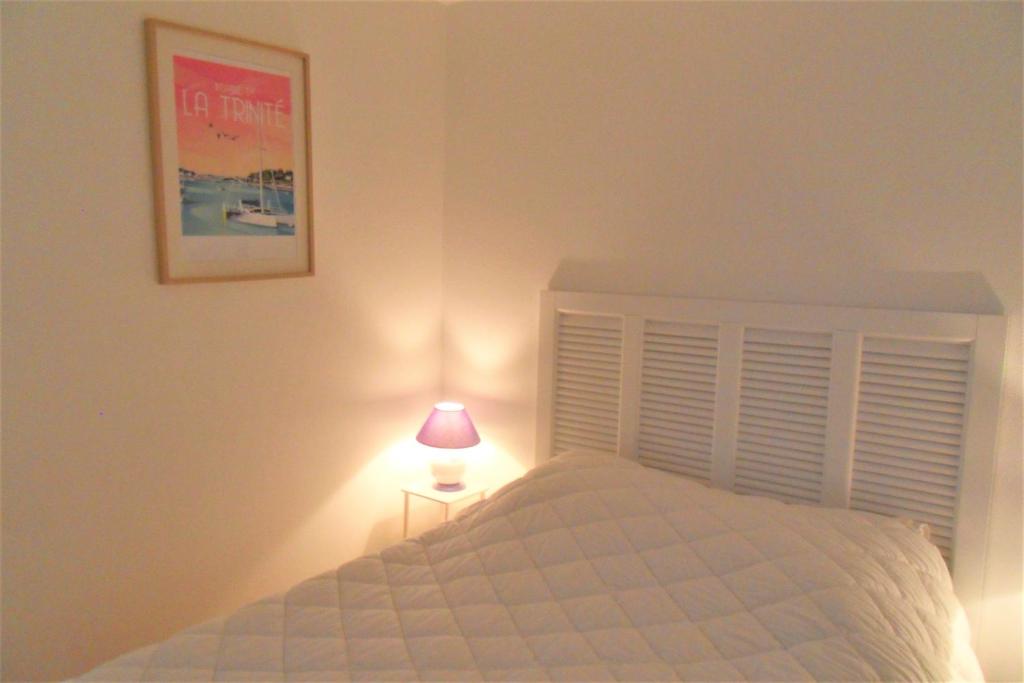 Guidel-PlageApt 6 pers - Magnifique vue mer - Belle terrasse - AZILIZ的一间卧室配有一张带台灯的床铺,