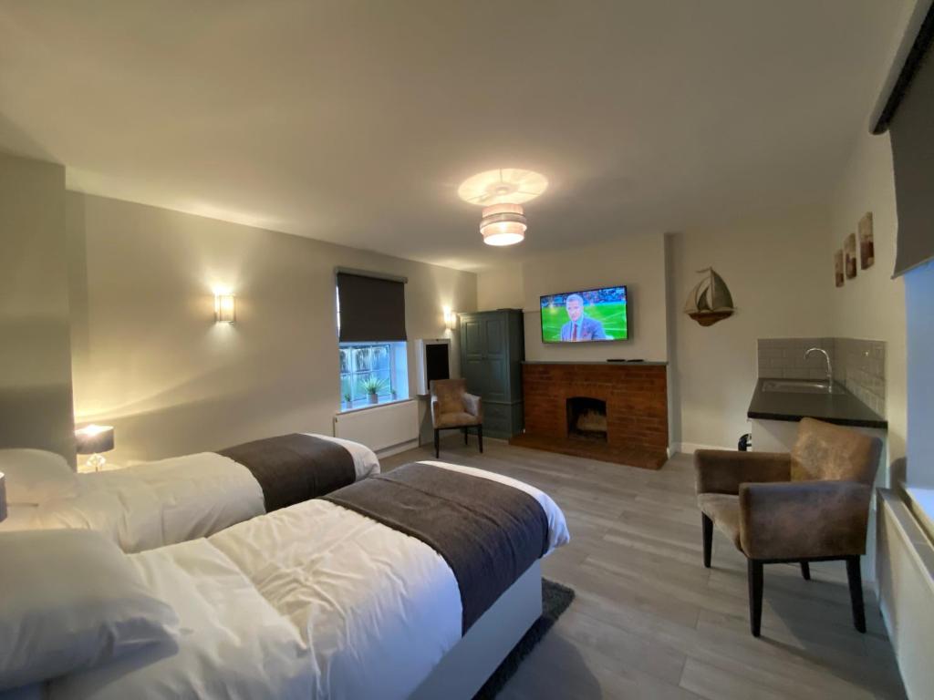 SharnbrookThe Fordham Inn的酒店客房设有两张床和一台平面电视。