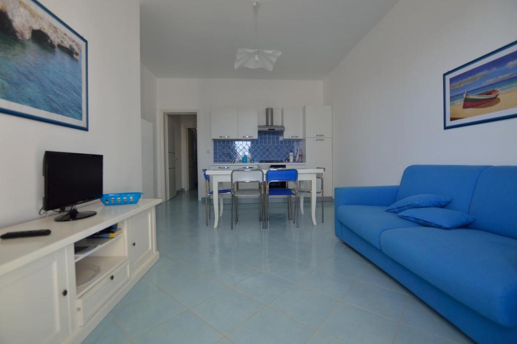 托雷瓦多Holiday Apartments Azzurro Salento的客厅配有蓝色的沙发和电视