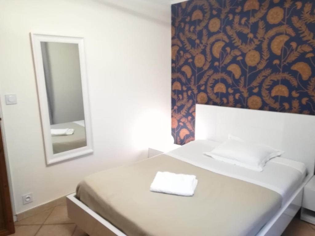 阿维尼翁新城Chambre avec tout le confort d'un appartement的卧室配有白色的床和镜子
