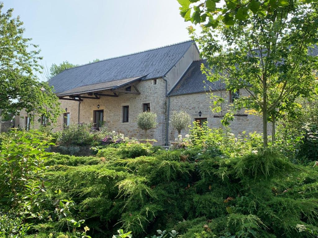 BrévandsHoliday home Haras du Ry的一座古老的石头房子,前面设有一个花园