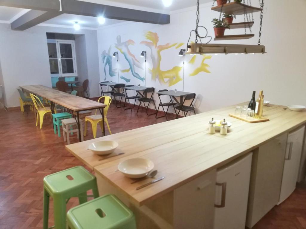 里斯本Draft Hostel & Rooms的厨房配有木台面和一些桌椅