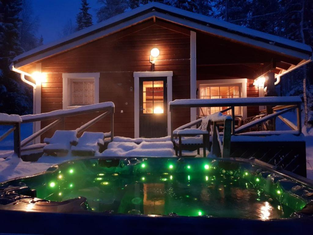 维拉特Villa Vaskela的小屋前的热水浴池配有圣诞灯