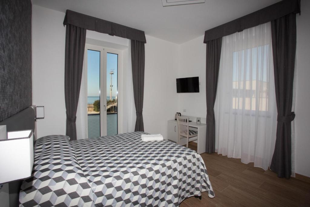 奇维塔韦基亚Guesthouse Porto di Roma的一间卧室设有一张床和一个大窗户