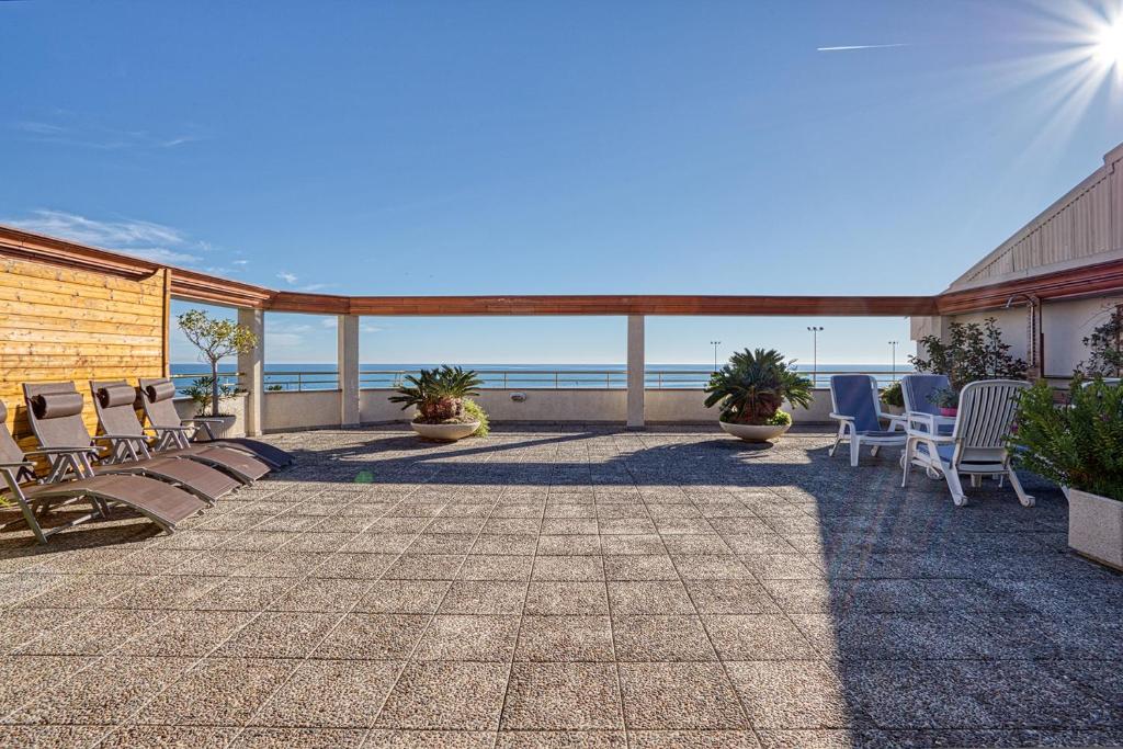 卡里拉Vistas al Mar. Gran Terraza的一个带椅子的庭院和背景海洋