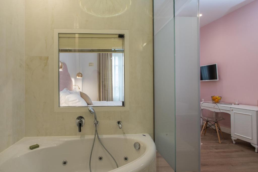 塞萨洛尼基Bahar Boutique Hotel的浴室配有浴缸及镜子