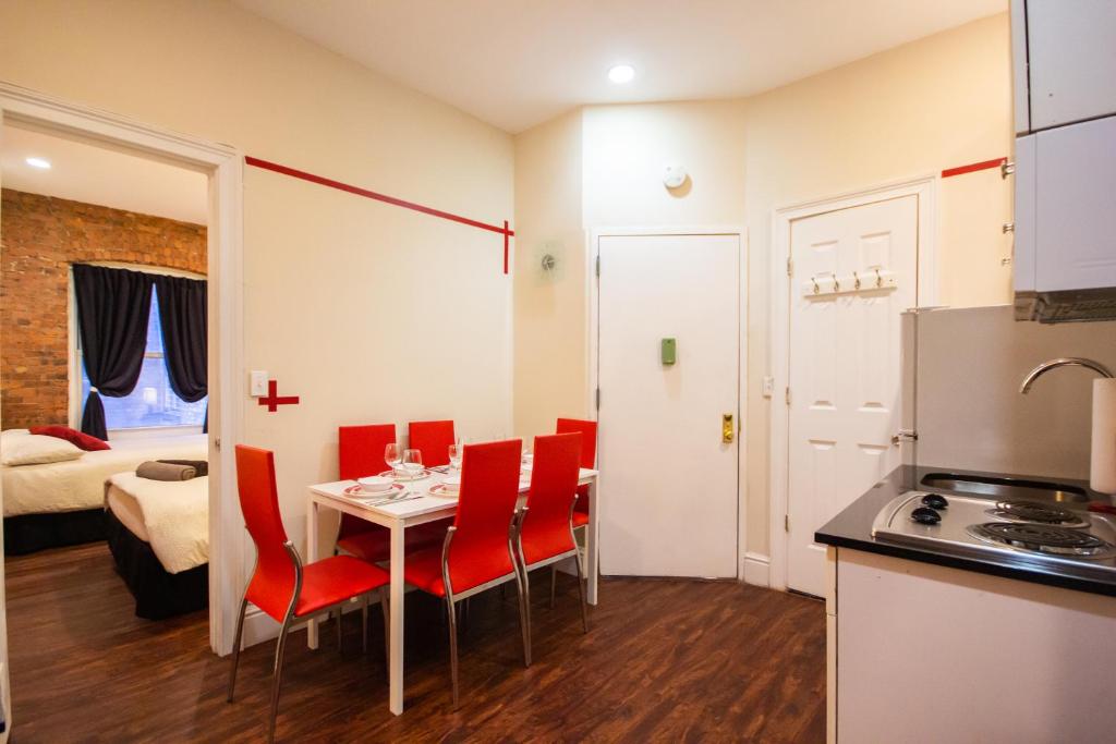 纽约STUDIO PLUS - 2 Bedroom Apartment in Midtown的厨房以及带桌椅的用餐室。