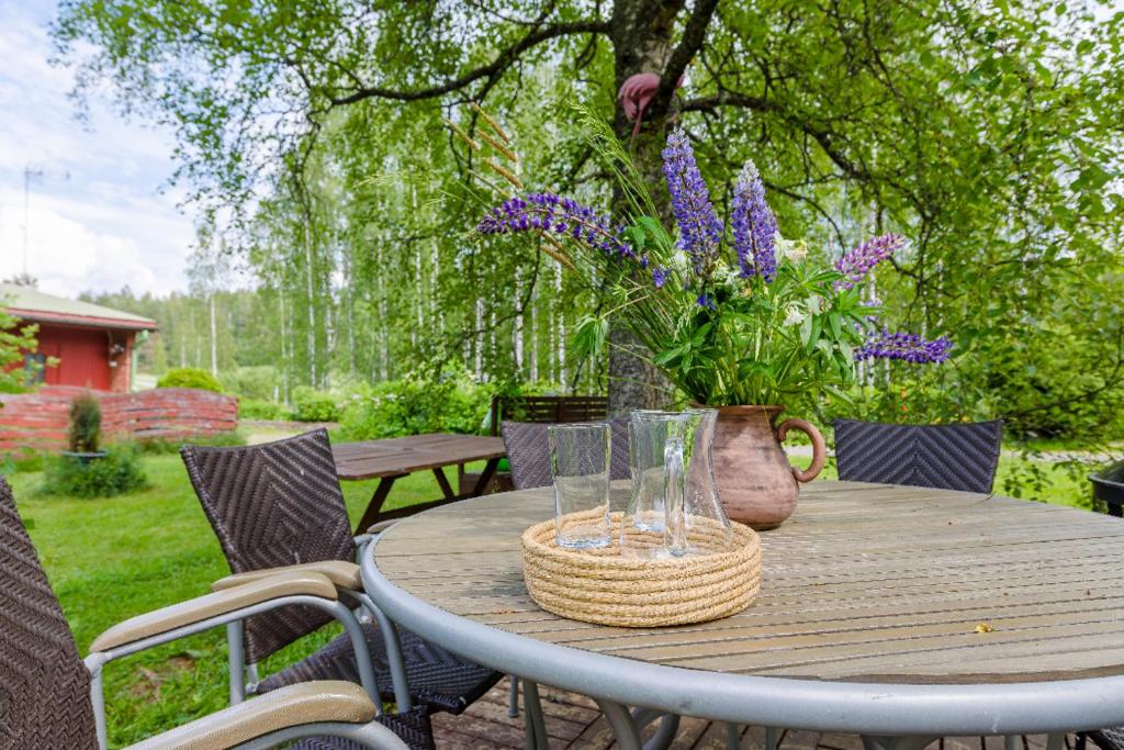 NuuksioPoppelstrand Nuuksio, Pet friendly guest apartment的一张木桌,上面有花瓶