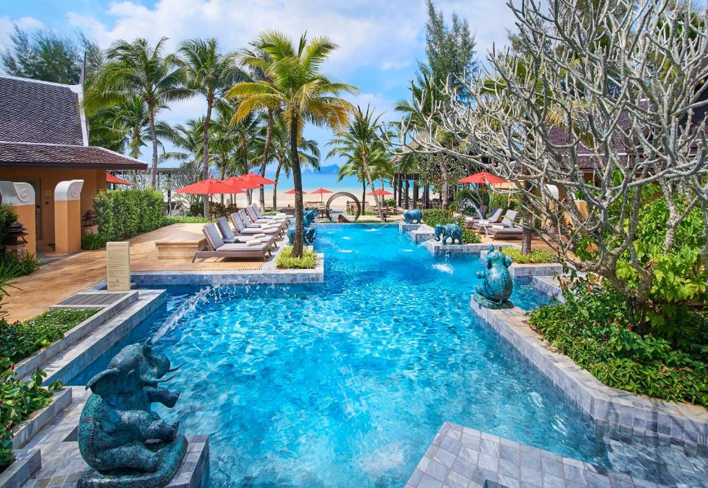 塔可克海滩甲米阿玛瑞时尚度假酒店的拥有蓝水和棕榈树的度假村的游泳池
