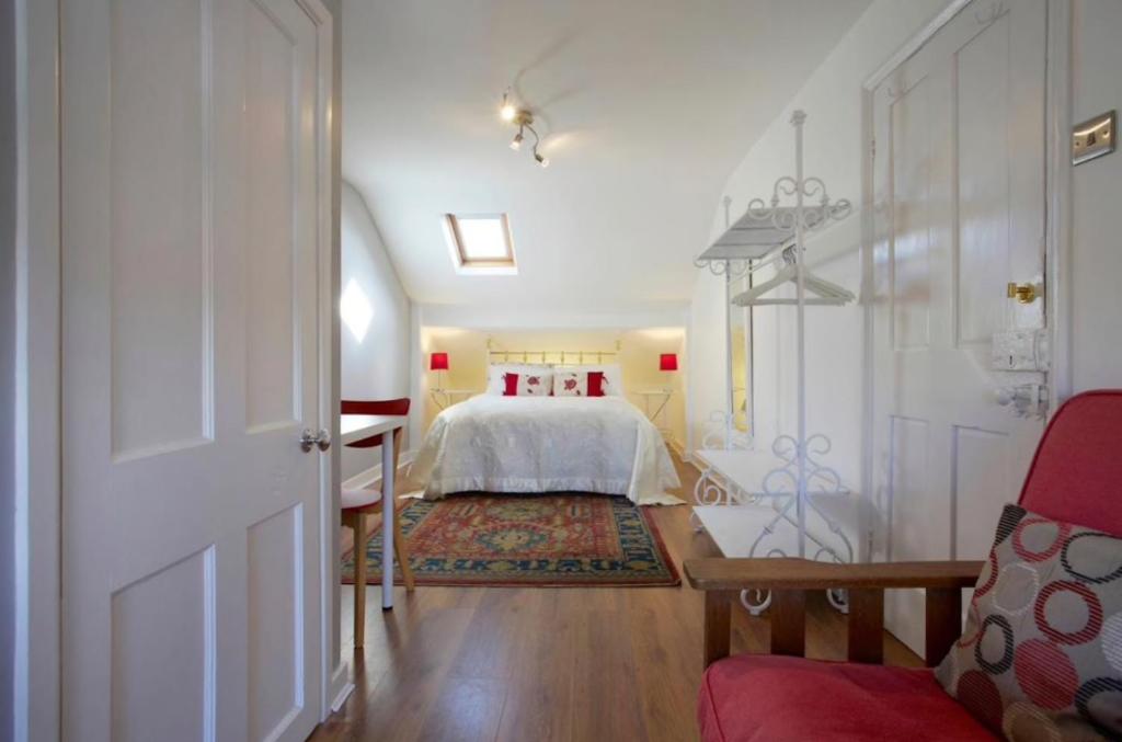 约克The Townhouse Central York的卧室配有白色的床和红色椅子