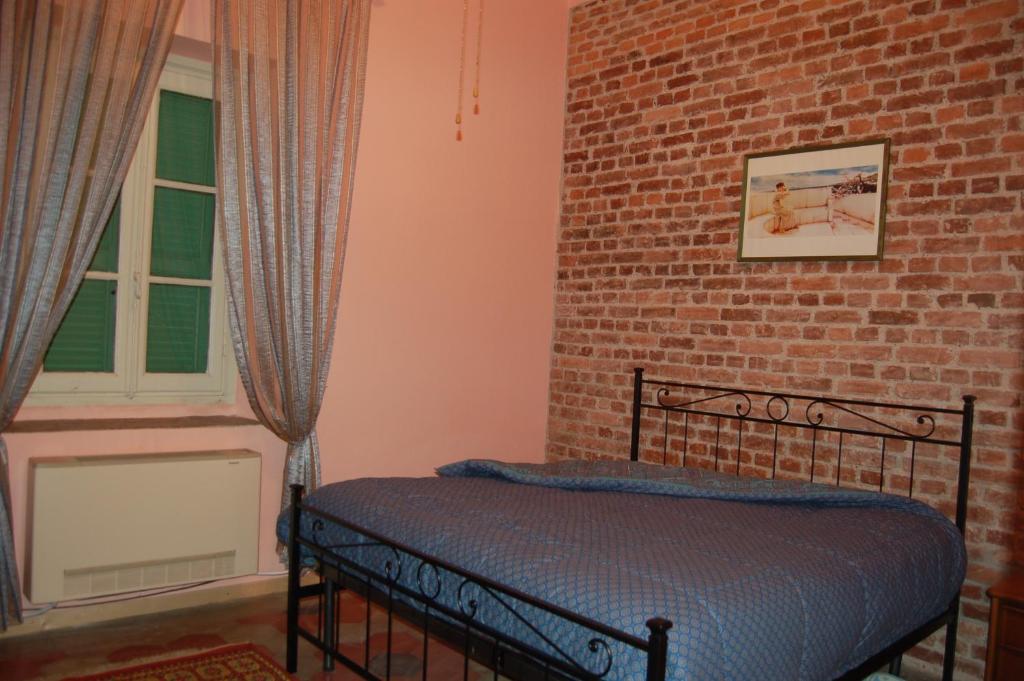 AlbizzateLaghi d'Insubria的卧室设有砖墙旁边的床