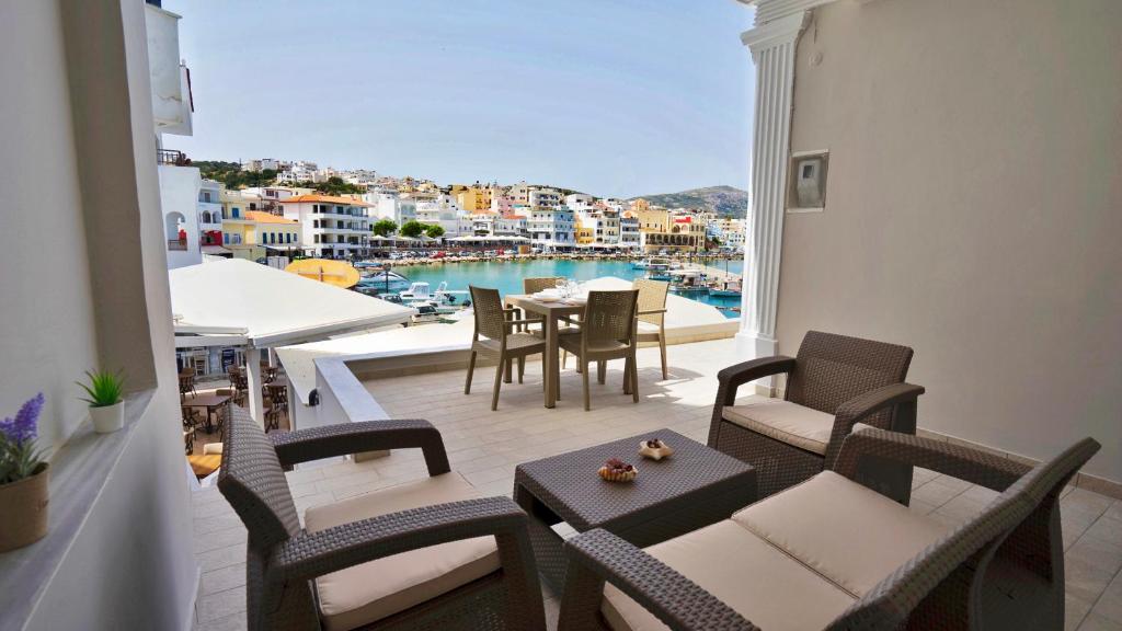 卡尔帕索斯Magic View Apartment-Karpathos Port Pigadia的阳台配有桌椅,享有水景。