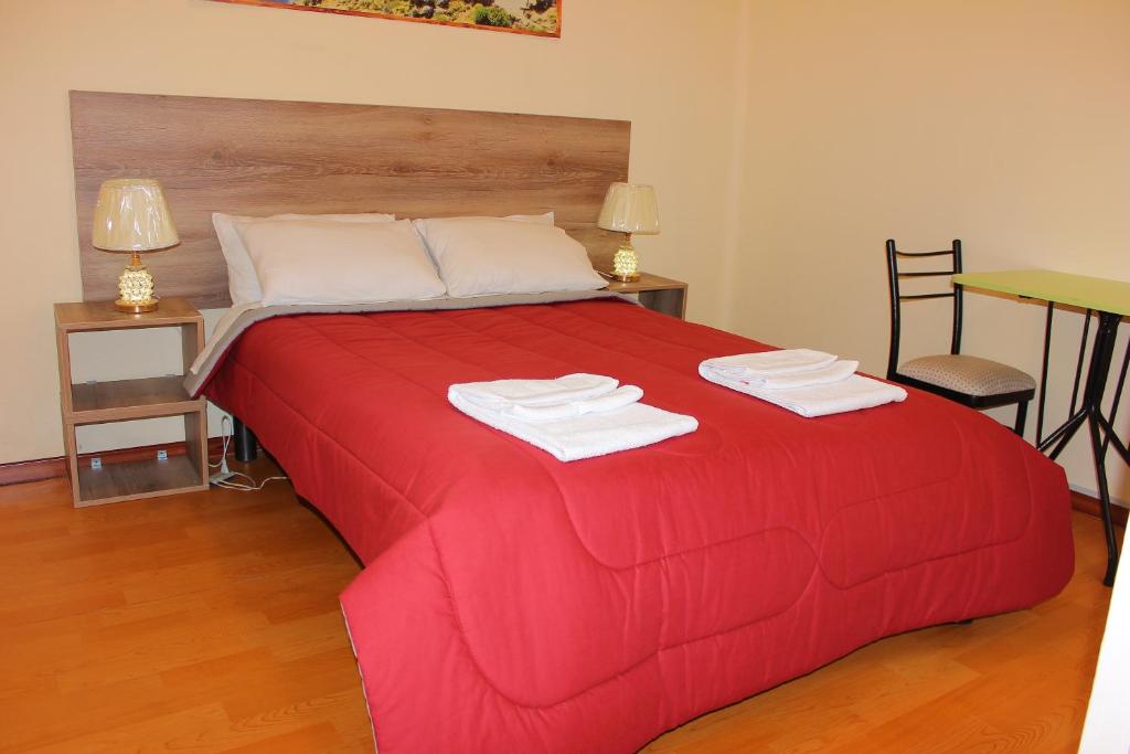 阿雷基帕Holidays Hostel Arequipa的红色的床,上面有两条毛巾