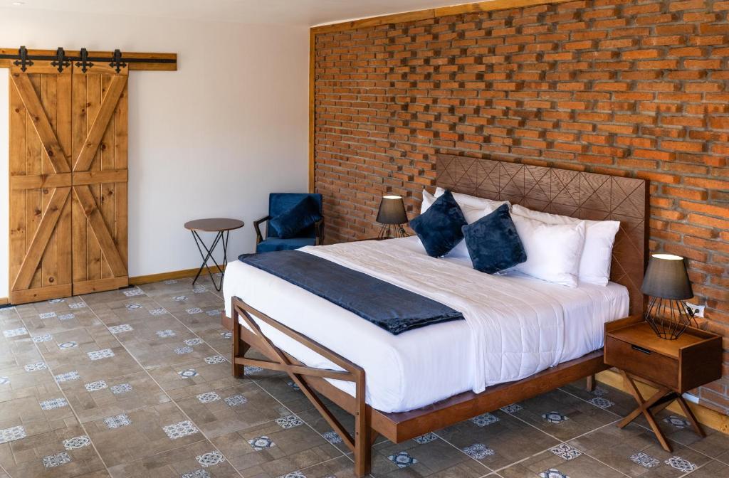 瓜达鲁佩镇OJO AZUL RESORT的一间卧室设有一张床和砖墙