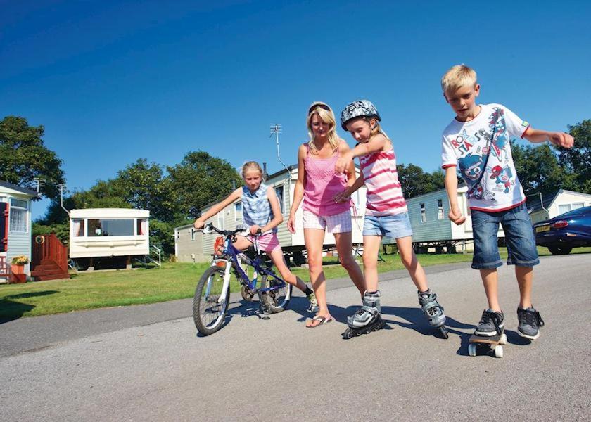 新罗姆尼Country Coastal Holidays - Families and Couples only的一群站在自行车旁的三个孩子