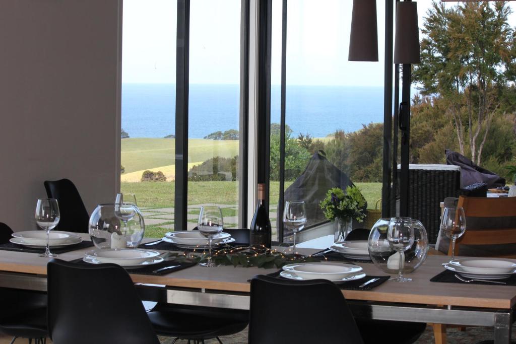 旺阿雷Te Kahu的一张桌子和酒杯,享有海景