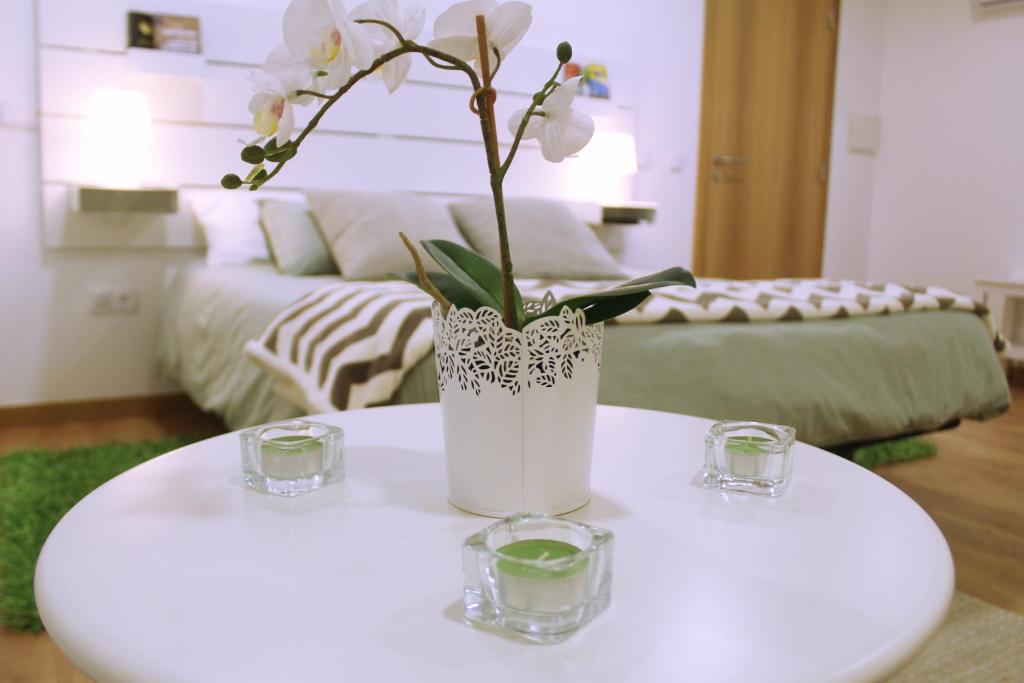 辛特拉Sintra Cozy Suite的客厅里白色花瓶,桌子上放着鲜花