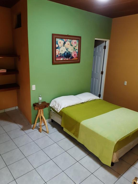 康塞普西翁德阿塔科Las Casitas Hostal-Ataco的一间绿色墙壁上的卧室,配有两张床