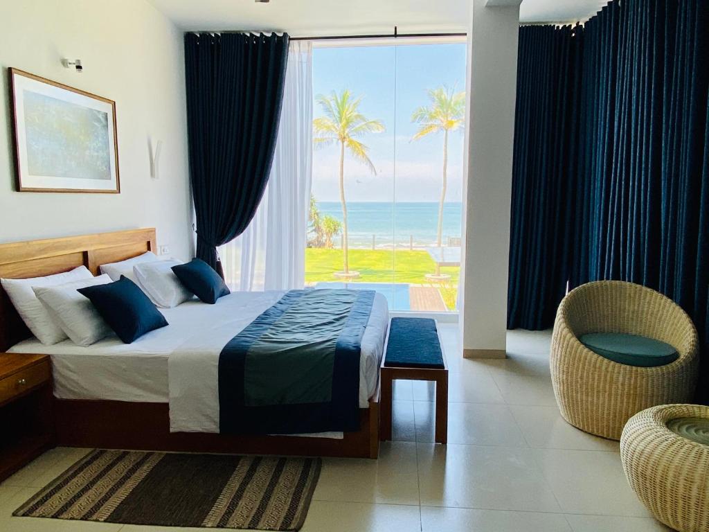 尼甘布The Lighthouse Negombo的一间卧室配有一张床,享有海景