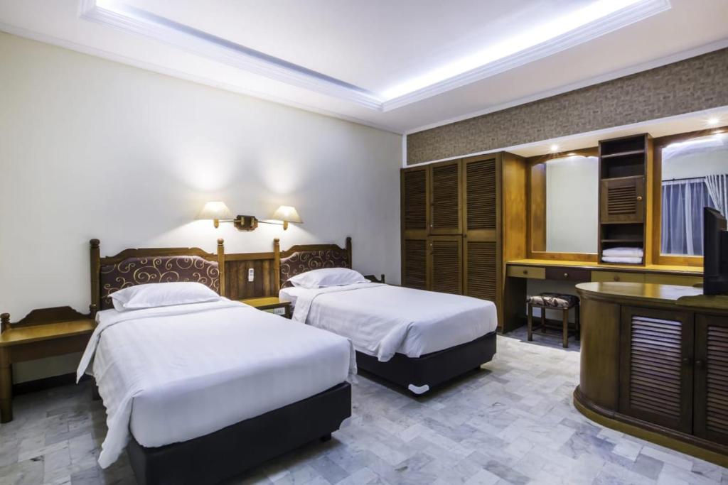 库塔巴厘别墅酒店的酒店客房设有两张床和电视。