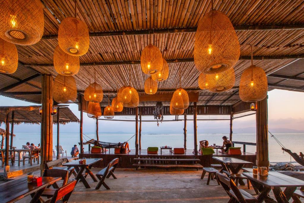通萨拉The Cosy Koh Phangan的一间带桌椅和灯光的餐厅
