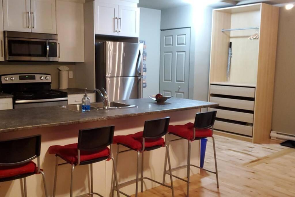加蒂诺1-Bedroom Apartment Bellisimo AG by Amazing Property Rentals的厨房配有带红色椅子的柜台。