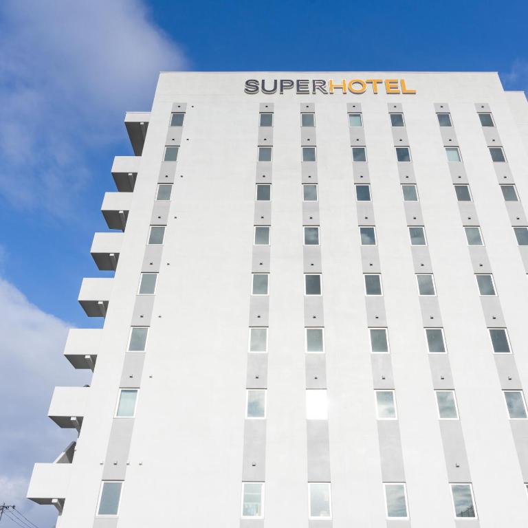 上越市Super Hotel Joetsu Myoko-Eki Nishiguchi的顶部有超级酒店标志的建筑