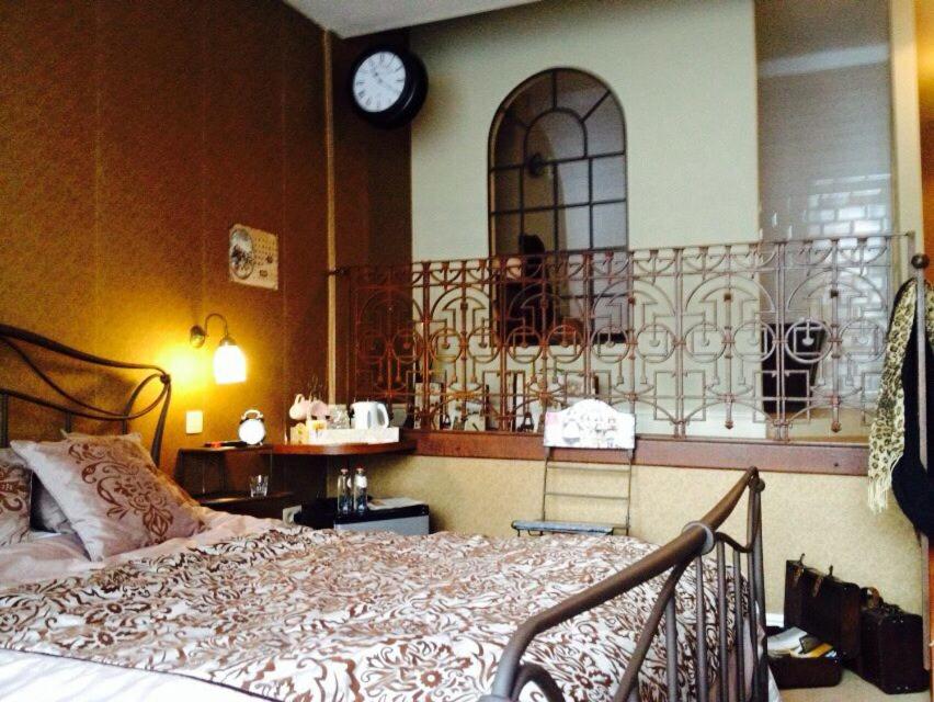 蒂伦豪特朋朋'不眠之夜'床和早餐的卧室配有一张床,墙上挂着一个钟