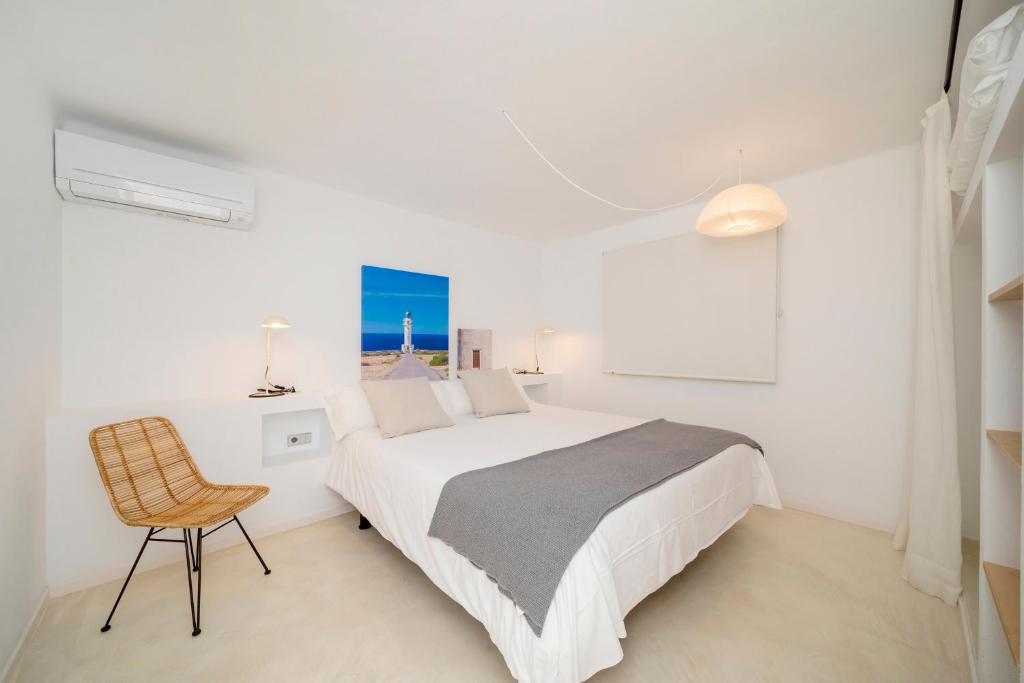 埃斯普霍斯Apartamentos Roca Plana的白色卧室配有床和椅子