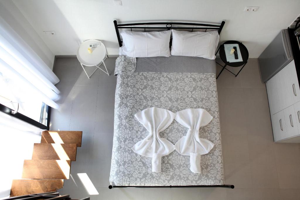 内亚卡瓦里Bebas Apartments Nea Karvali的一间卧室,床上有两双白鞋