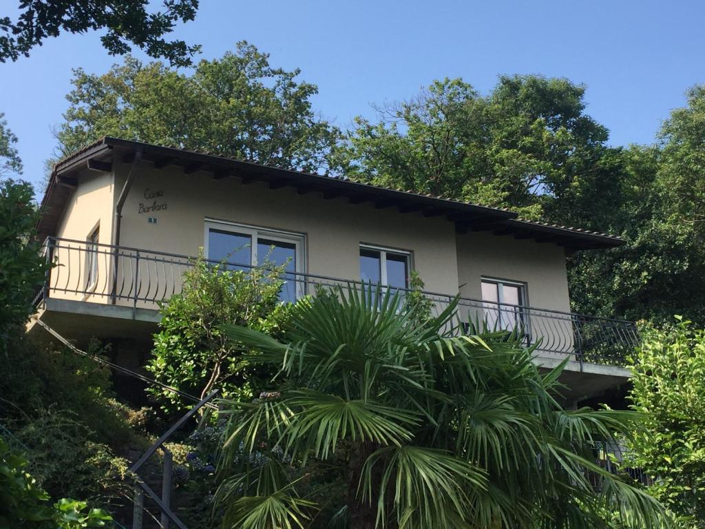 卡罗纳Casa Barbara - eine Oase der Ruhe oberhalb des Lago di Lugano的树中间带阳台的房子