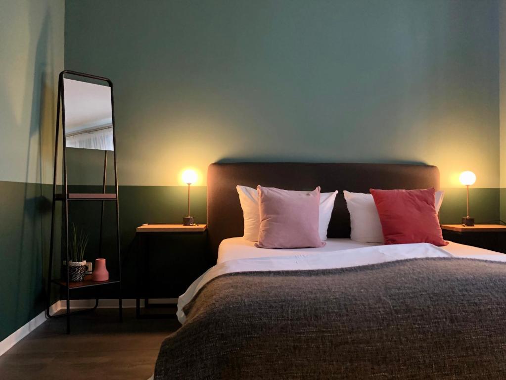 魏玛Pension Mariposa的一间卧室配有带枕头和镜子的床