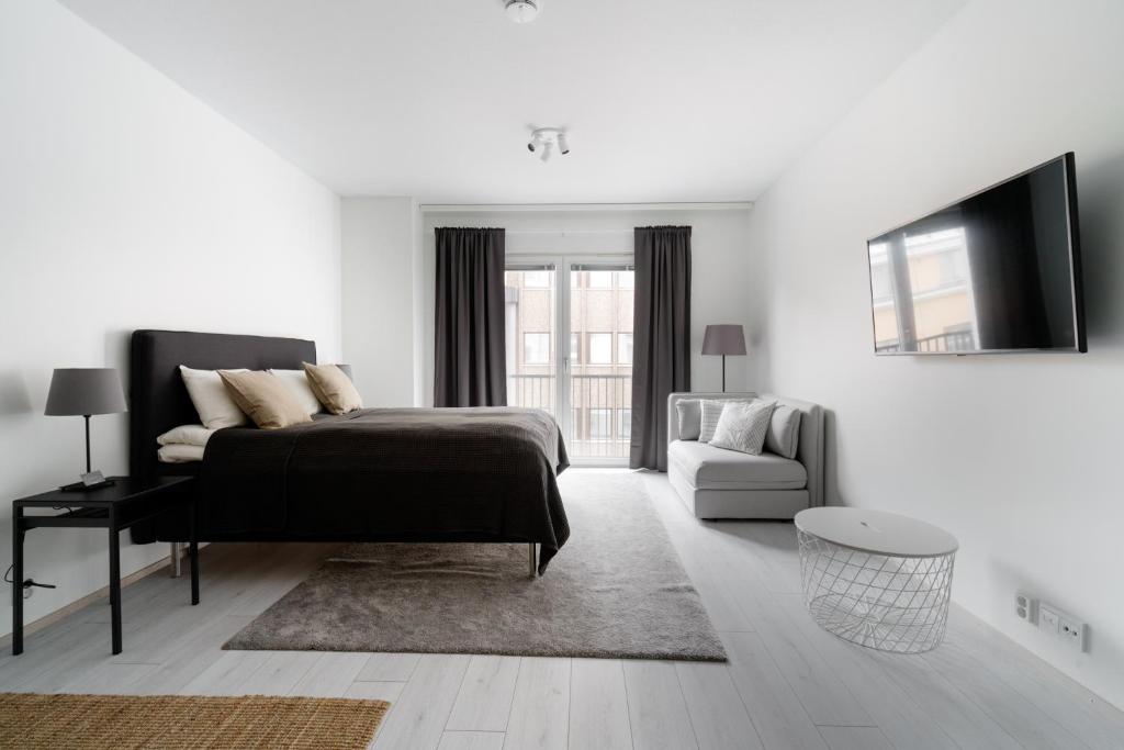 奥卢ULEABO New 37m2 Studio的白色卧室配有床和沙发