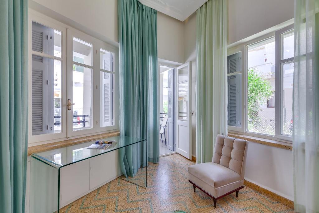 干尼亚Samouil Apartment, 40 meters from the beach的客房设有窗户、玻璃桌和椅子。