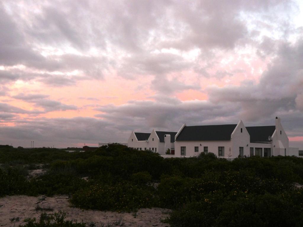DwarskersbosJubel n Juig Self Catering的一片云天的海滩上的白色房子