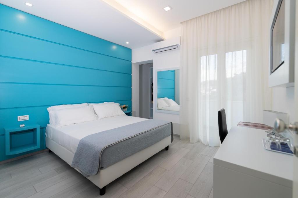 特罗佩阿Dreams Tropea Mare的一间卧室设有蓝色墙和一张床