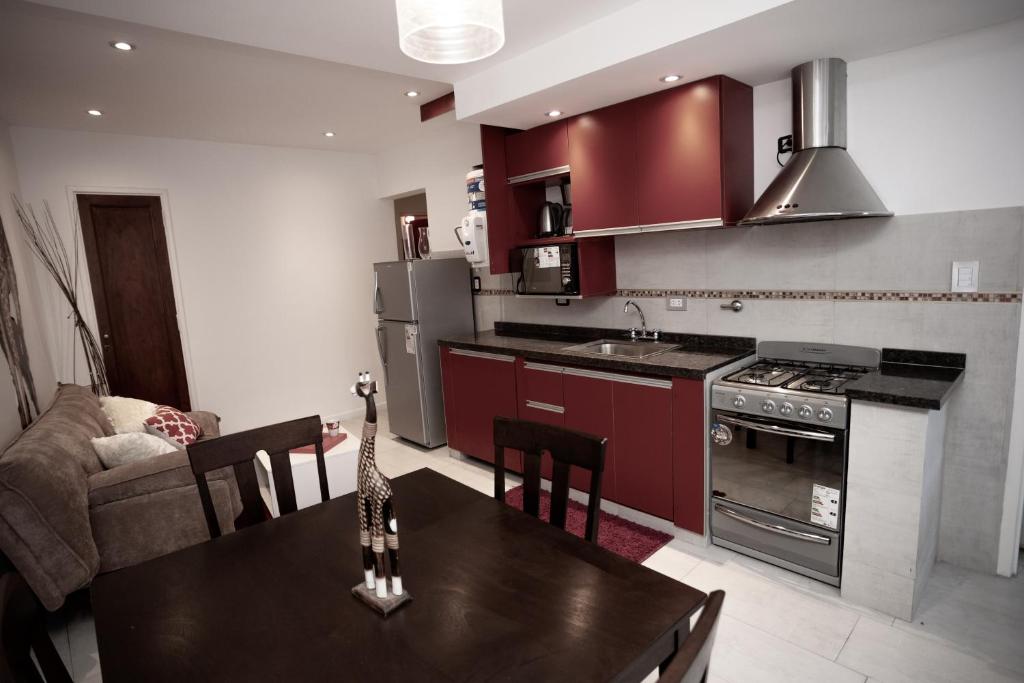 拉法尔达9 ¾ Apartamentos VIP的厨房配有红色橱柜和桌椅