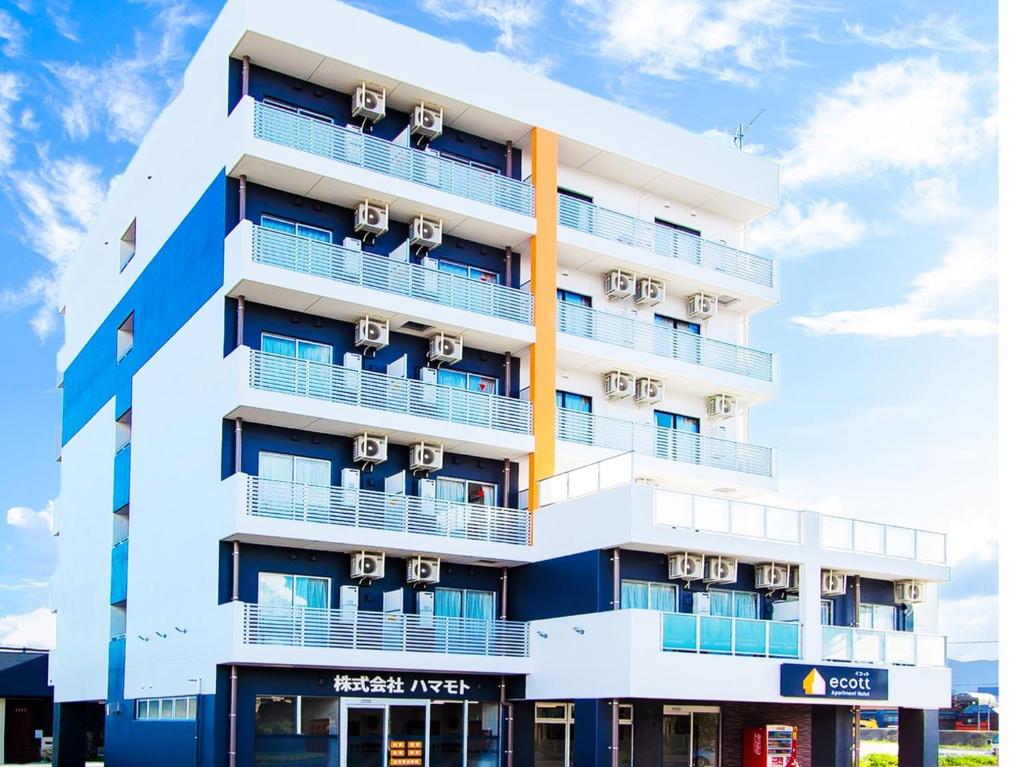 鹿儿岛Apartment Hotel Ecott的公寓大楼设有白色和蓝色的阳台