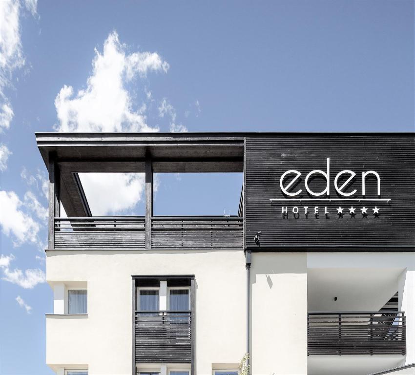 雷西亚Eden Boutique Hotel的一座黑白的建筑,上面有标志