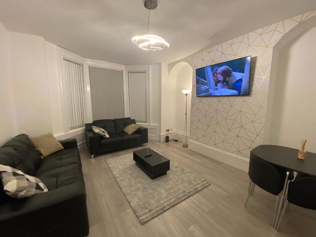 泰恩河畔纽卡斯尔Heaton Park Road Professional Lets的客厅配有沙发和墙上的电视